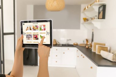 İnternetten alışveriş yapmak için dijital tablet kullanan kadın