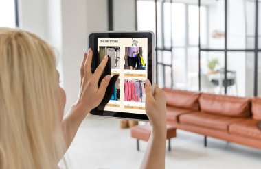 İnternetten kıyafet alan bir kadın. Tablet kullanan kadın