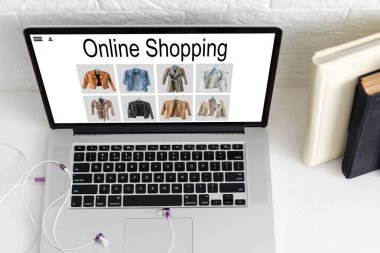 Alışveriş, teknoloji ve internet kavramı: hayali bir dükkanda dizüstü bilgisayarla alışveriş