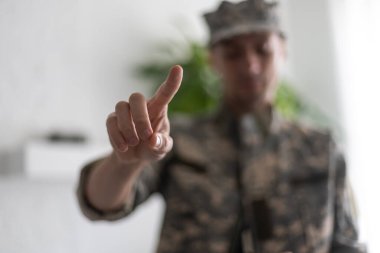 Beyaz arka planda izole edilmiş asker işaret parmağıyla geriye doğru işaret ediyor..