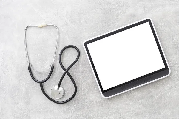 Medical equipment: stethoscope and tablet on grey background — Stock Photo, Image