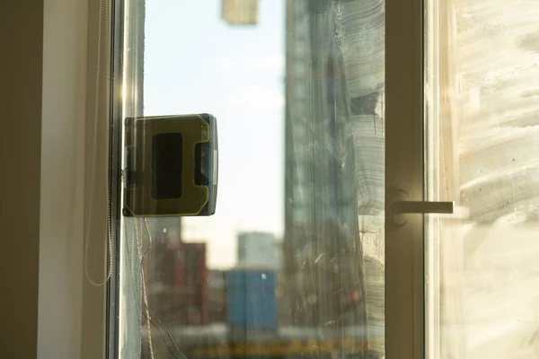 로봇 창문 청소부가 더러운 창문 작업을 하고 있어. 현명 한 장치로 집안을 청소 한다. 창문을 청소하기 위한 자동 진공청소기, 가정 의보 조자 — 스톡 사진