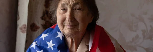 Ανώτερη γυναίκα με αμερικανική σημαία κάθεται στο σπίτι — Φωτογραφία Αρχείου