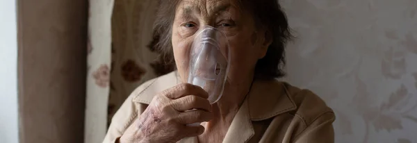 Close-up portrait of an elderly woman making inhalation — Stock Photo, Image