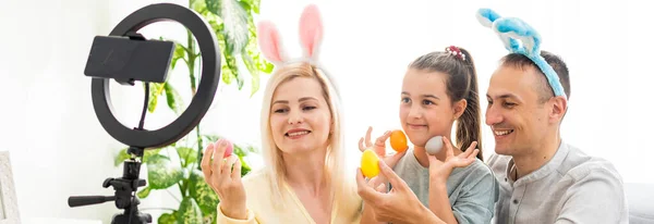 Familjesamtal på telefon i köket inrett för påsk. Påsk — Stockfoto