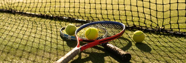 Tenisová raketa a nový tenisový míček na čerstvě natřeném tenisovém kurtu — Stock fotografie