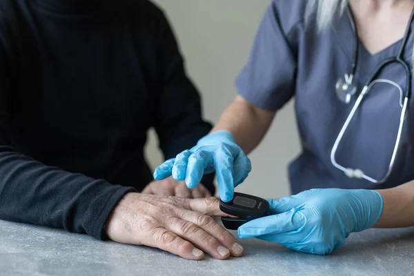 Ältere Menschen messen ihren Puls mit den Fingerspitzen in einer Pflegeeinrichtung — Stockfoto