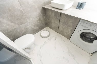 Banyoda beyaz robot elektrikli süpürge.
