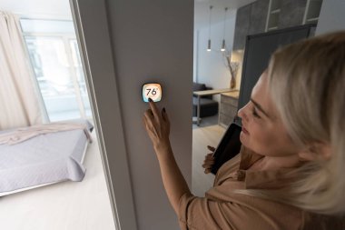 Akıllı duvar ev kontrol sistemi kullanan kadın