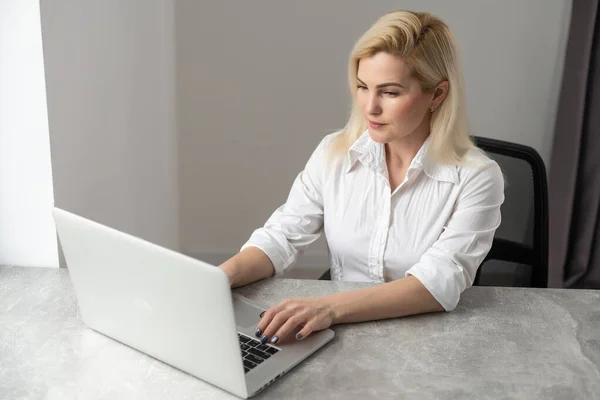 Wizerunek młody zadowolony szczęśliwy wesoły ładny ładny biznes kobieta siedzieć w biurze za pomocą laptopa — Zdjęcie stockowe