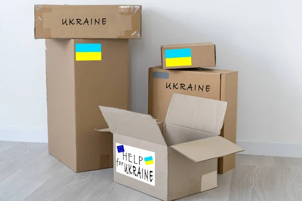 Box with donation clothes for ukrainian refugees suffering from war. Charity and Helping poor and needy people. Stay with Ukraine