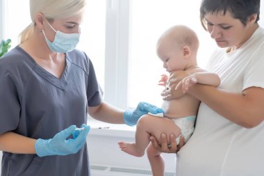 Çocuk doktoru küçük çocuğa aşı yapıyor.