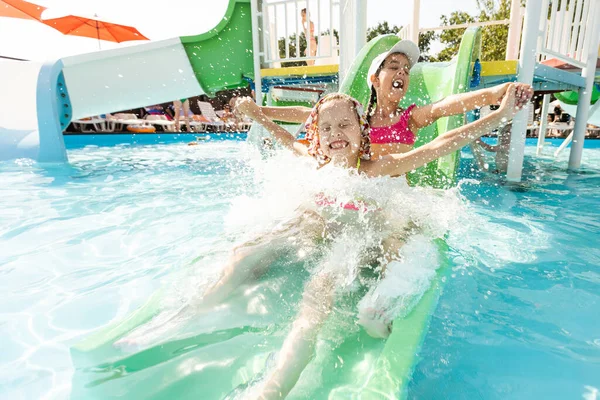 Dos niñas pequeñas diversión saltando en la piscina — Foto de Stock