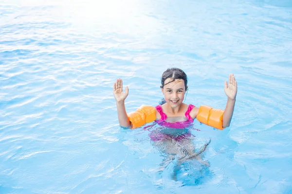Счастливая маленькая девочка развлекается в бассейне в купальнике. — стоковое фото