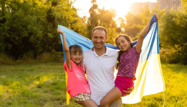 Ukrajina Den vlajek Nezávislosti. Den ústavy. rodina s vlajkou Ukrajiny v terénu. 24. srpna. Vlastenecká dovolená. — Stock fotografie