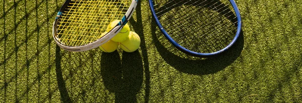 Tenis raketi ve yeni boyanmış tenis kortunda yeni bir tenis topu.