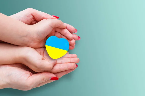 The national flag of ukraine with the coat of arms in female hands. Flat lay, copy space — Stock Photo, Image