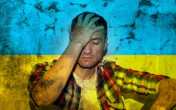 Depresyonda olan olgun bir adamın karanlıkta tek başına çifte pozu savaş konseptini ve Ukrayna bayrağını durdurur. — Stok fotoğraf