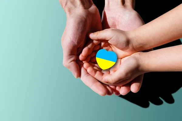 La bandera nacional de Ucrania con el escudo de armas en manos femeninas. Colocación plana, espacio de copia —  Fotos de Stock