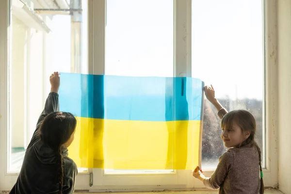 Zwei kleine Mädchen mit ukrainischer Flagge — Stockfoto