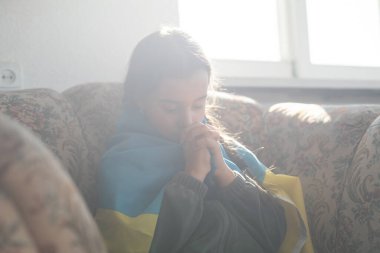 Ukrayna için dua et. Ukrayna bayrağı taşıyan bir çocuk. Ulusal bayrak sallayan küçük kız barış için dua ediyor..
