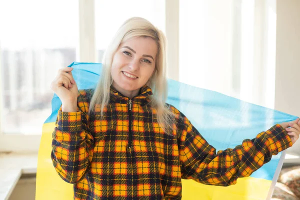 Flüchtlingsfrau mit ukrainischer Flagge — Stockfoto