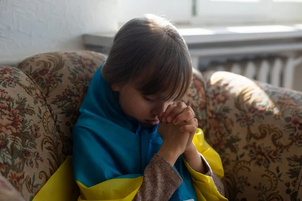 Liten flicka täckt med Ukraina flagga. Begreppet stående med ukrainska nationen i krig med Ryssland. — Stockfoto