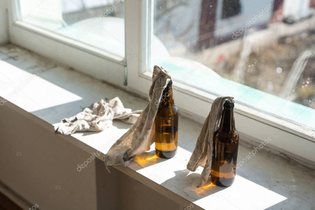 Glass bottle filled with gasoline, a so called Molotov Cocktail, on the window in the house