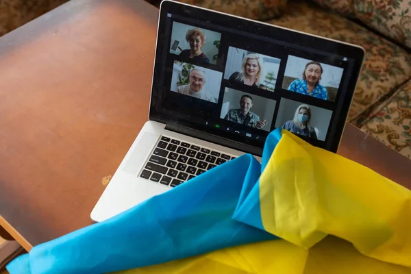 Ноутбук с видео рядом с флагом Украины — стоковое фото