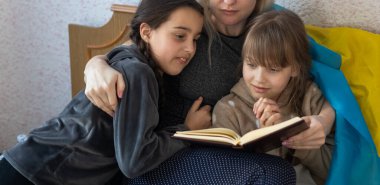 Ukraynalı genç anne ve kızı Ukrayna bayrağı taşıyor. Rusya ile Ukrayna arasındaki savaş sırasında barış için dua ediyor. Rusya 'nın Ukrayna' daki işgali.