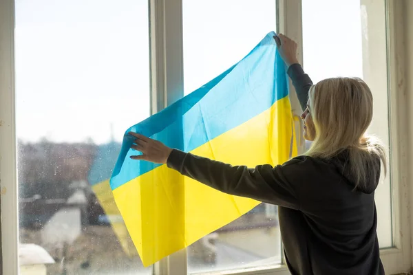 Flüchtlingsfrau mit ukrainischer Flagge — Stockfoto