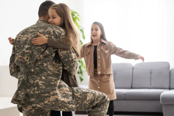 Feliz pai militar e duas filhas em casa. — Fotografia de Stock
