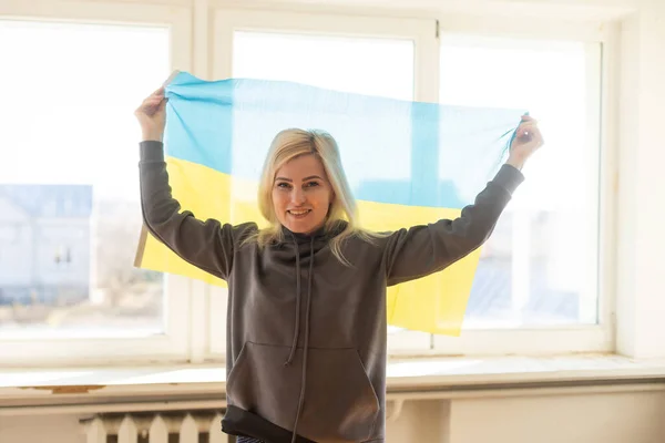 Flüchtlingsfrau mit ukrainischer Flagge — Stockfoto