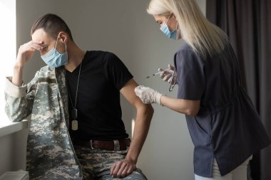 Üniformalı asker klinikte Corona virüsüne karşı aşı oluyor. Askeri aşı ve aşılama