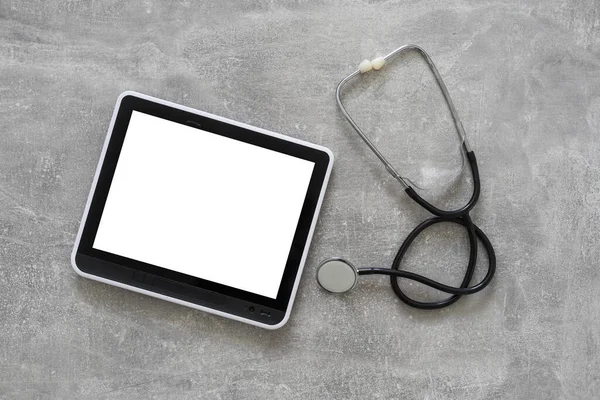 Medical equipment: stethoscope and tablet on grey background — Stock Photo, Image