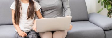 Yardımsever anne, kızına dizüstü bilgisayar kullanmasını anlatıyor.