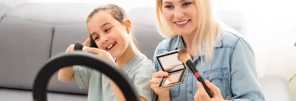 Ragazzina utilizzando smart phone con la madre in cucina. — Foto Stock