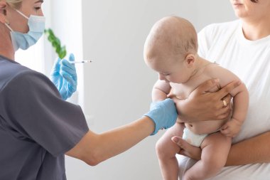Çocuk doktoru küçük çocuğa aşı yapıyor.