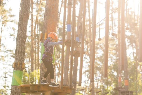Happy school meisje genieten van activiteit in een klimmen avonturenpark op een herfstdag — Stockfoto