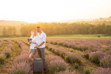 Erkek ve kadın, lavanta tarlasında yaşam tarzı ve yolcu pasaportu ile seyahat eder.