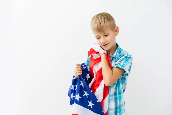 Blonde boy waving national USA flag outdoors over white background. American flag, patriotism, independence day 4th july concept — Stock Photo, Image