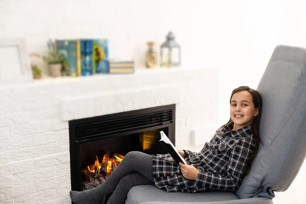 Porträtt av en vacker liten flicka som läser en bok — Stockfoto