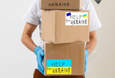 Bir adam içinde Ukrayna 'ya insani yardım olan bir kutu tutuyor.