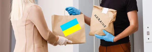 Чоловік тримає коробку з гуманітарною допомогою Україні — стокове фото