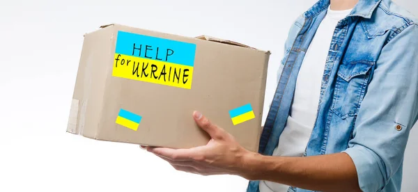 Человек держит коробку с гуманитарной помощью Украине — стоковое фото