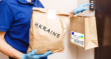 Bir adam içinde Ukrayna 'ya insani yardım olan bir kutu tutuyor.