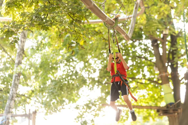 Çocuk tırmanışçı ip köprüde yürüyor,