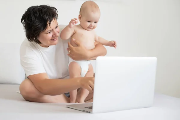 stock image Mom and baby looking at a laptop and smiling happy.