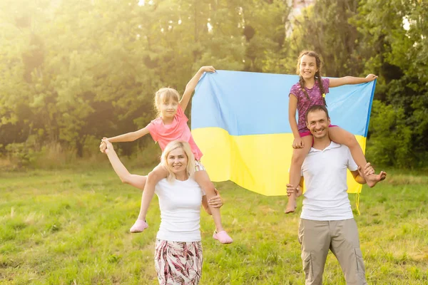 Ukraines Independence Flag Day. Verfassungstag. Familie mit der Fahne der Ukraine auf dem Feld. 24. August. Patriotischer Feiertag. — Stockfoto