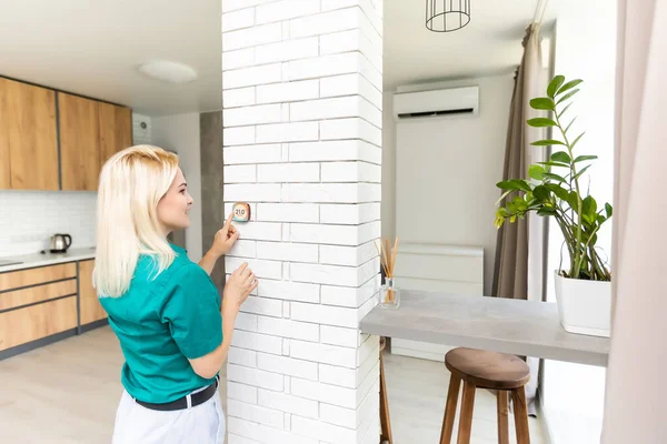 Gülümseyen Kadın Isıtma Sisteminde Termostatı Ayarlıyor